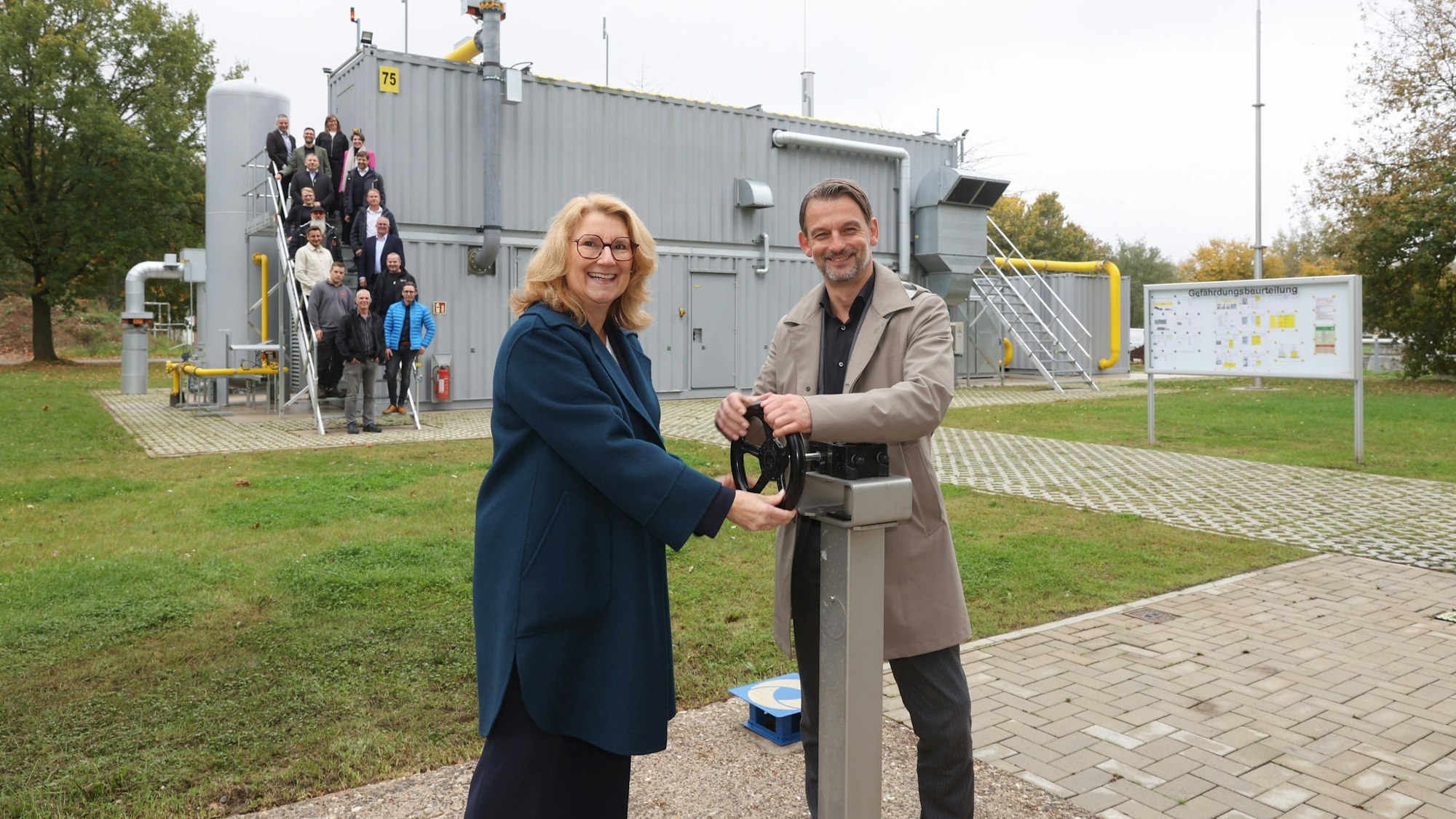 Ulrike Franzke und William Wolfgramm drehen an einem Rad der neuen Biogasanlage.