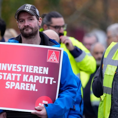 29.10.2024, Köln: Ein Arbeiter hält ein Schild mit der Aufschrift "Investieren statt Kaputt-Sparen" während eines bundesweiten Warnstreiks der IG Metall beim Automobilhersteller FORD in Köln. Foto: Martin Meissner/AP +++ dpa-Bildfunk +++