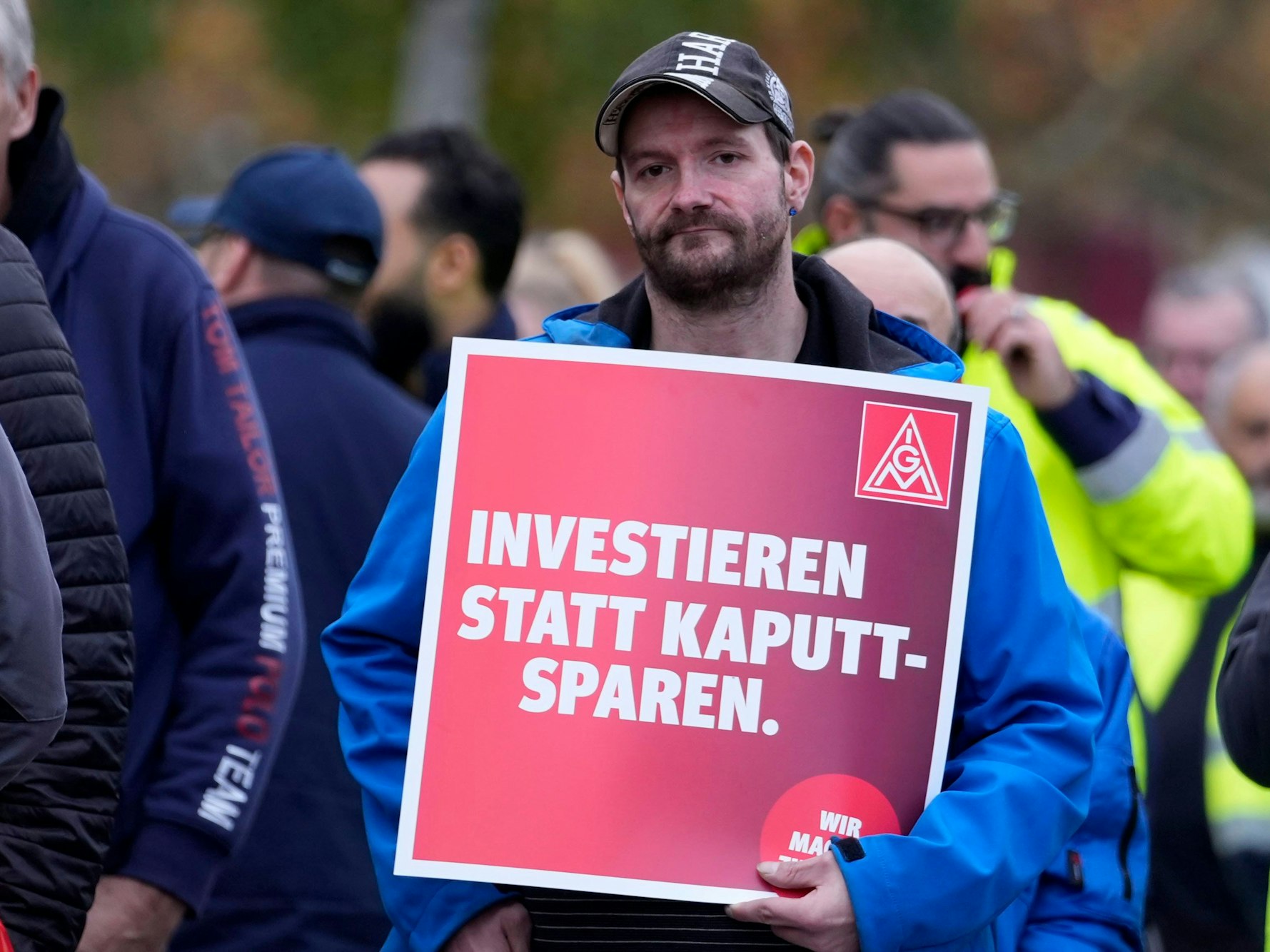 29.10.2024, Köln: Ein Arbeiter hält ein Schild mit der Aufschrift "Investieren statt Kaputt-Sparen" während eines bundesweiten Warnstreiks der IG Metall beim Automobilhersteller FORD in Köln. Foto: Martin Meissner/AP +++ dpa-Bildfunk +++