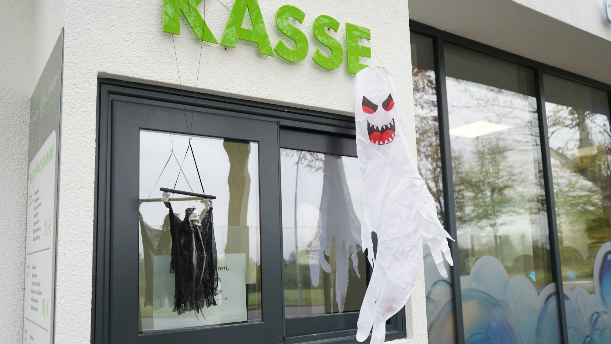 Das Foto zeigt ein Kassenhäuschen, vor dem Halloween-Deko hängt.