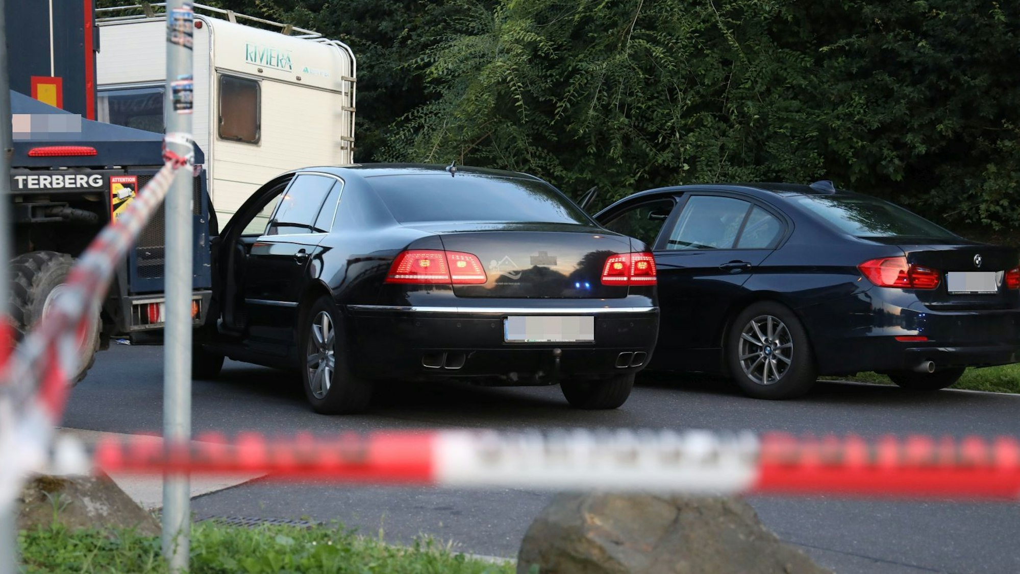 Drei Autos hinter einer Polizeiabsperrung.