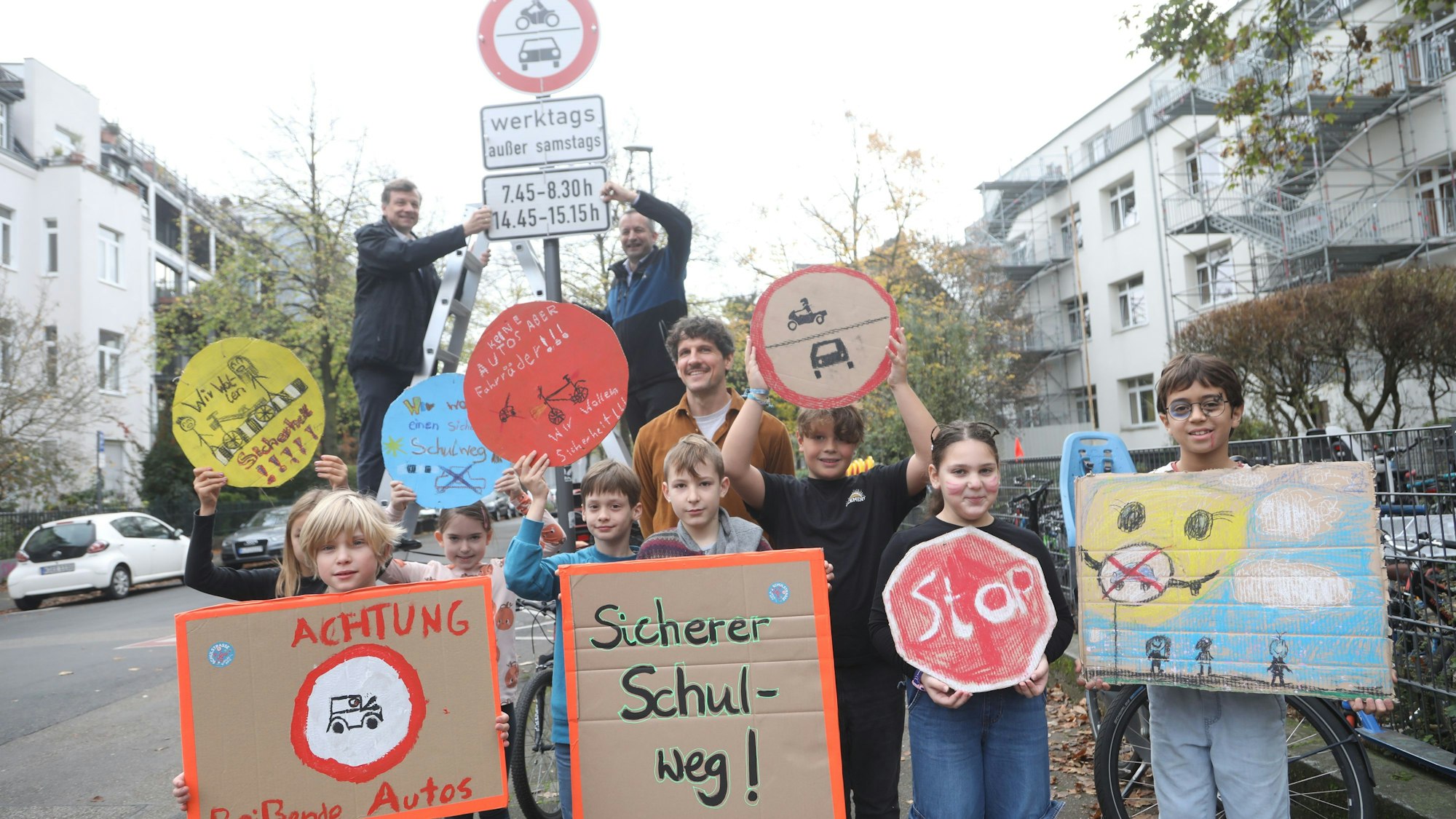 Das Foto zeigt eine Gruppe von Kindern vor dem neuen Schild der Schulstraße.