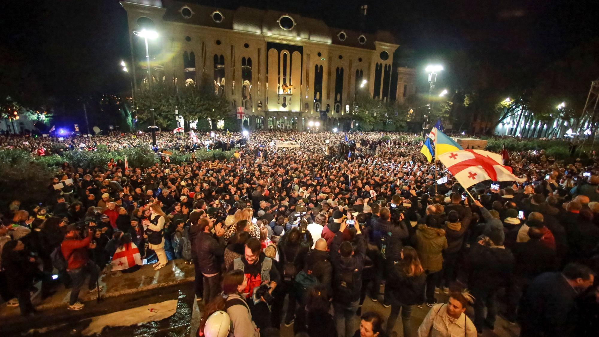 28.10.2024, Georgien, Tiflis: Demonstranten schwenken georgische und ukrainische Nationalflaggen während einer Protestaktion der Opposition gegen die Ergebnisse der Parlamentswahle.