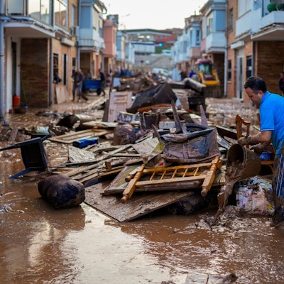 30.10.2024, Spanien, Utiel: Ein Mann reinigt sein von den Überschwemmungen betroffenes Haus.