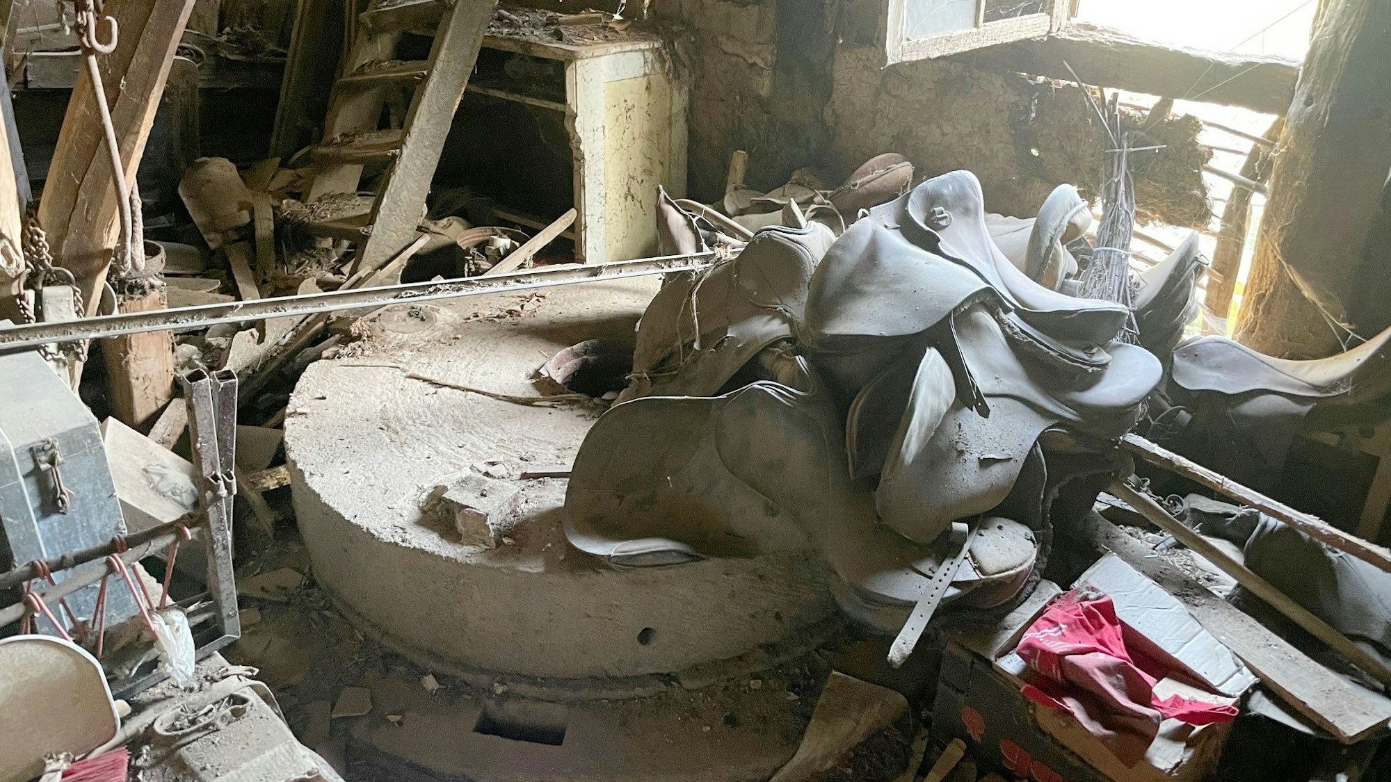 Das Bild zeigt den Mühlstein. Auch zahlreiche Sattel sind zu sehen.