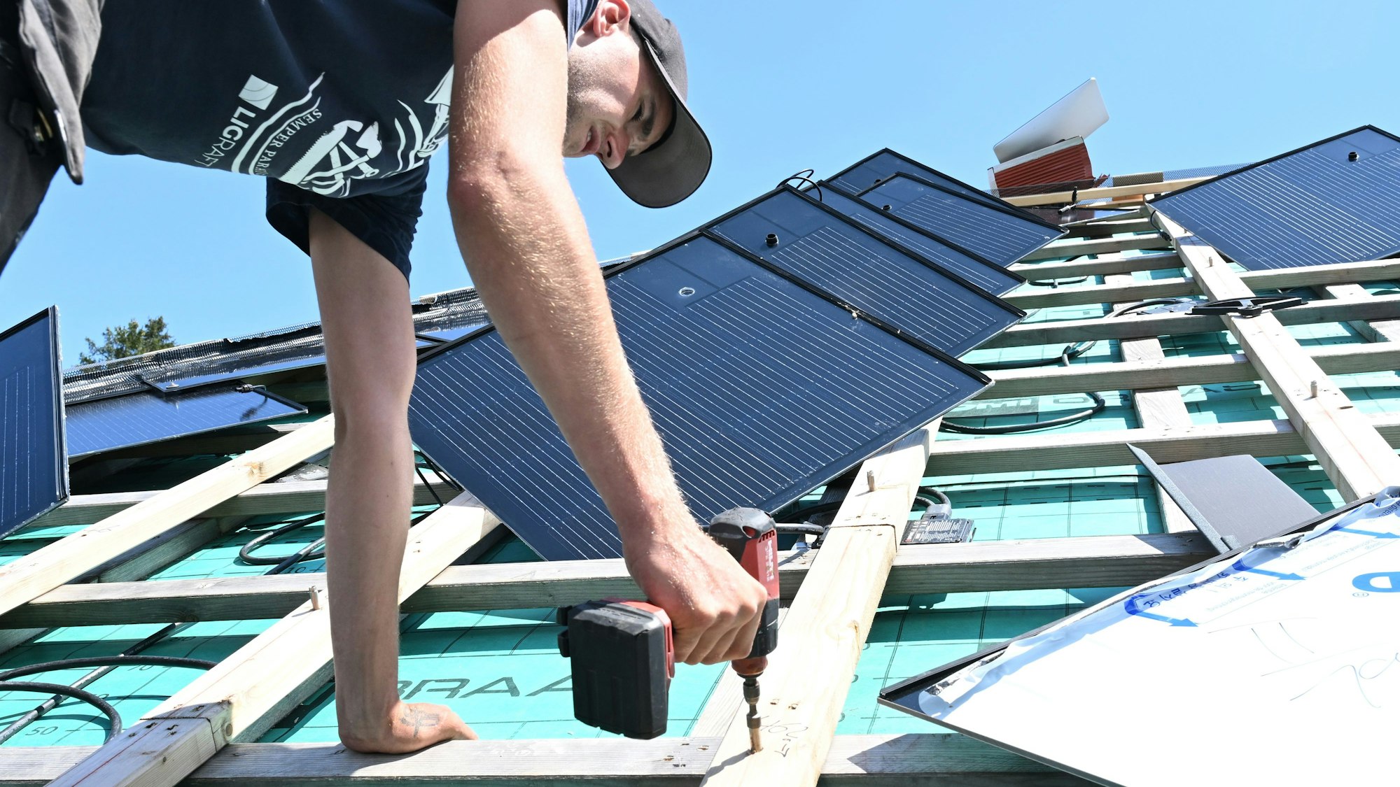 Handwerker arbeiten an einem Photovoltaik-Dach.