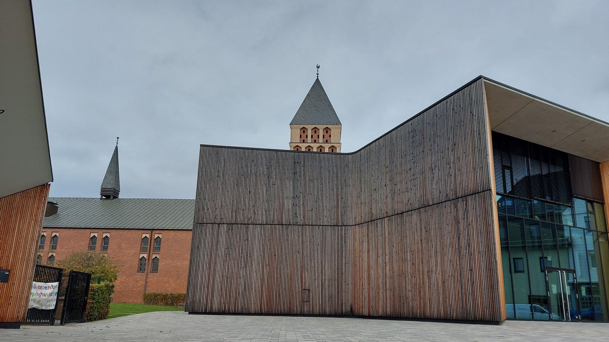 Ein moderner Bau mit großer Glasfassade und Holzverkleidung.
