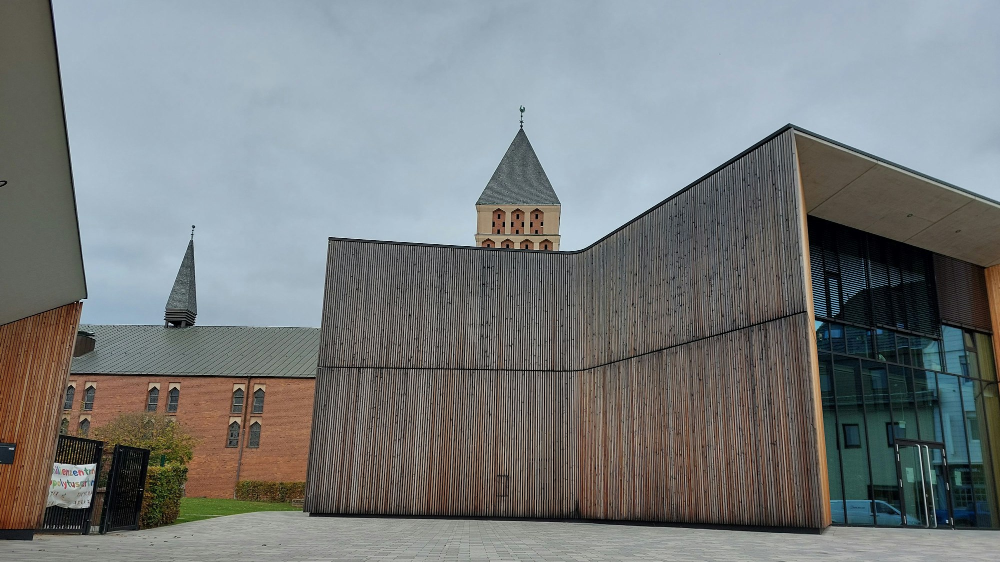 Ein moderner Bau mit großer Glasfassade und Holzverkleidung.