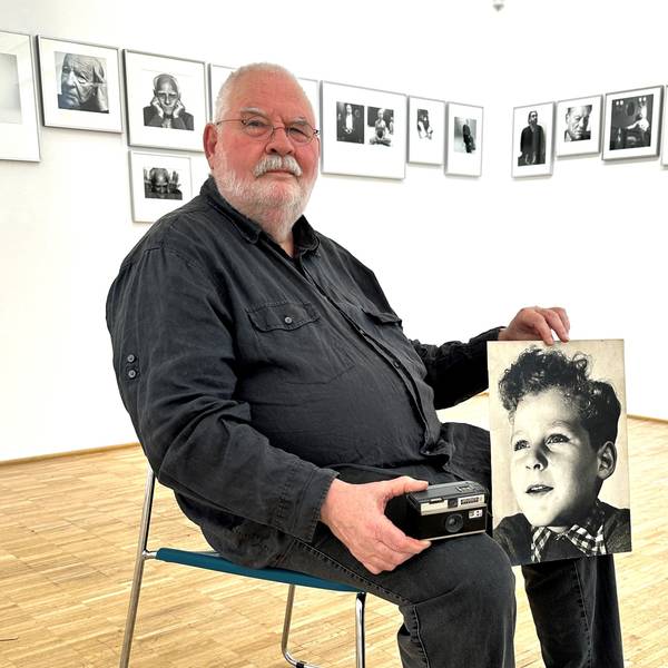 Der Fotograf Gerd van Rijn aus Nümbrecht mit der alten Instamatic und dem Porträtfoto seiner selbst als Junge. In seiner Heimatgemeinde ist ihm nun eine Ausstellung gewidmet.