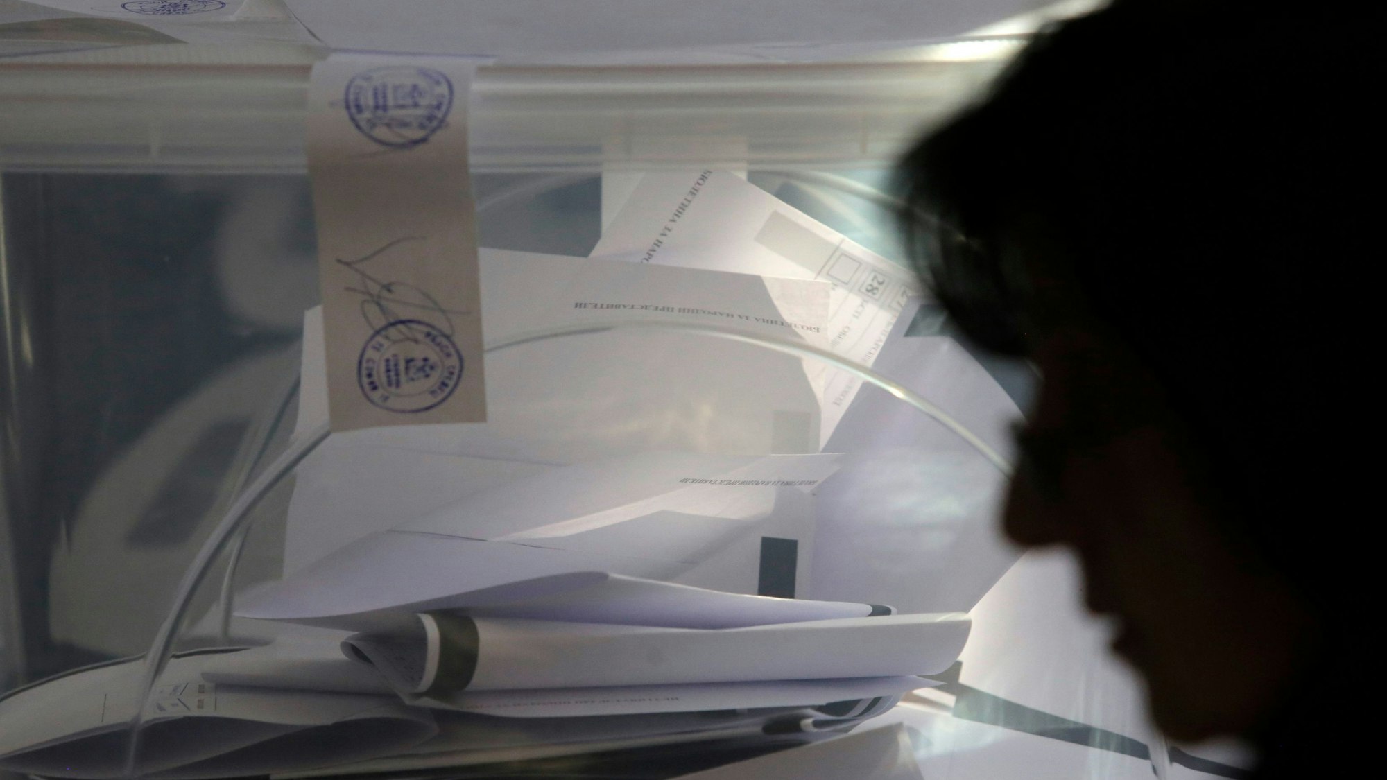Eine Person geht am 27. Oktober 2024 an einer Box mit Stimmzetteln vorbei in einem Wahllokal in Sofia während der Parlamentswahlen in Bulgarien. Zum siebten Mal innerhalb von dreieinhalb Jahren wird in Bulgarien ein neues Parlament gewählt.