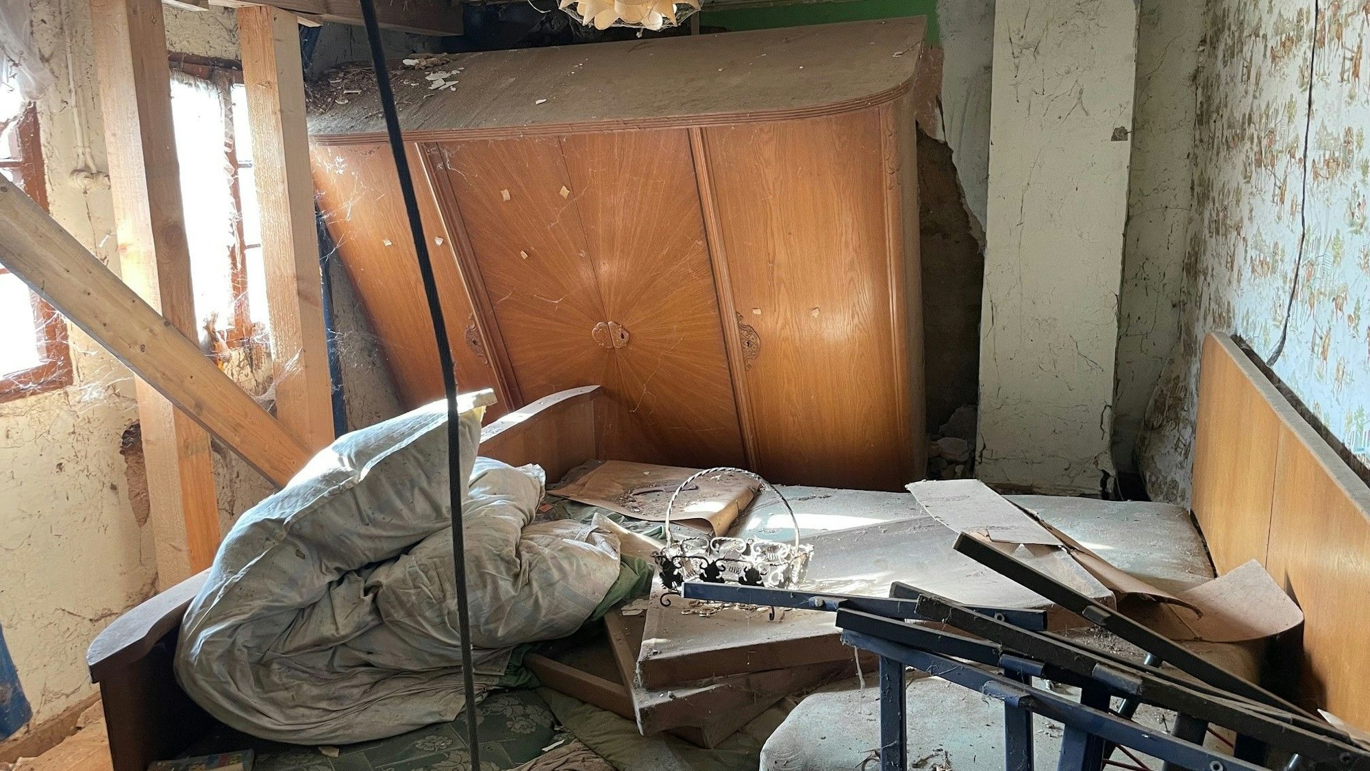 Ein Blick ins Schlafzimmer: Ein Bett und ein fast umgestürzter Schrank.