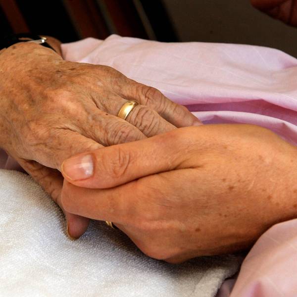 Die Hand einer Frau hält die einer anderen (Symbolfoto).