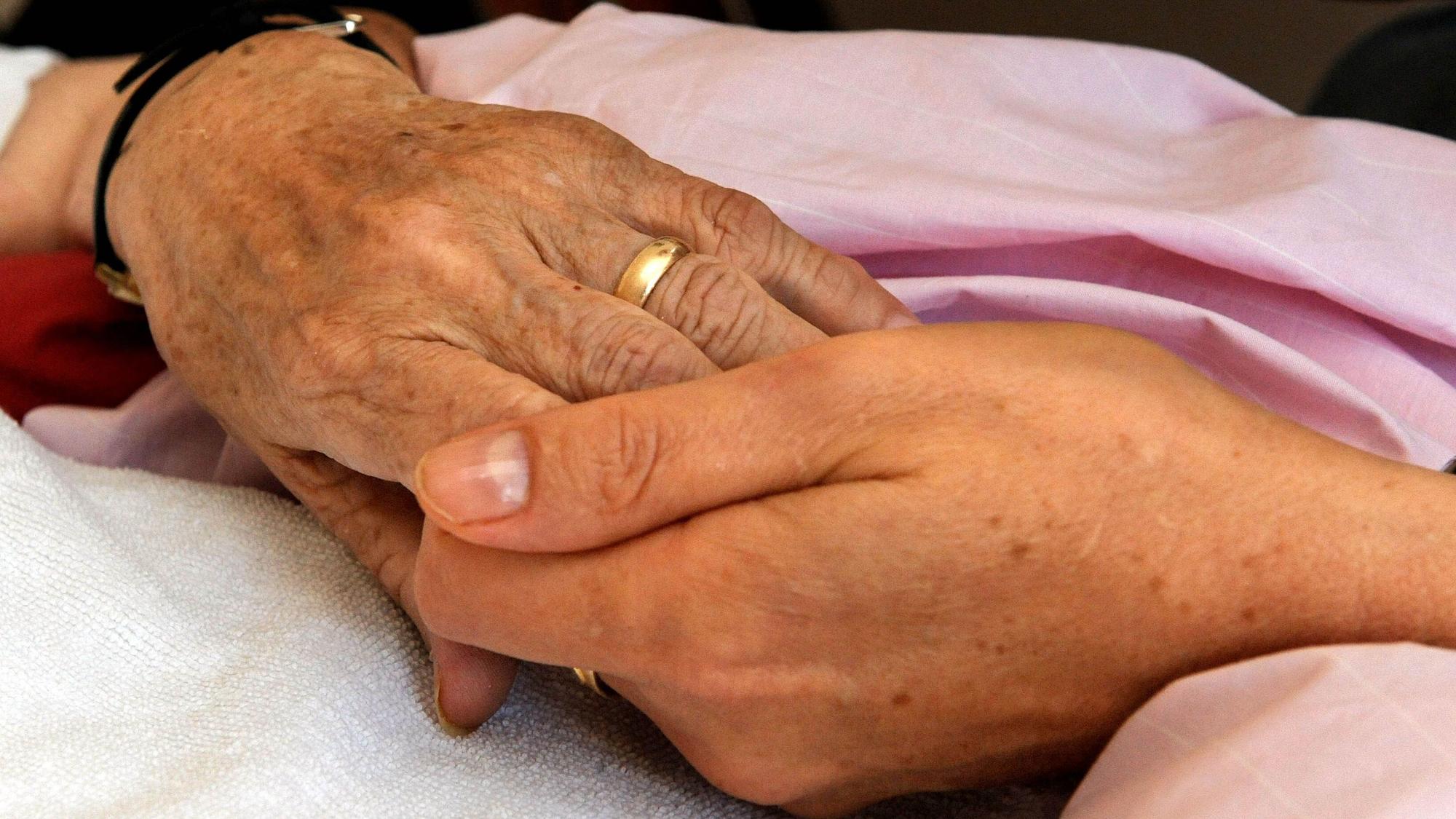 Die Hand einer Frau hält die einer anderen (Symbolfoto).