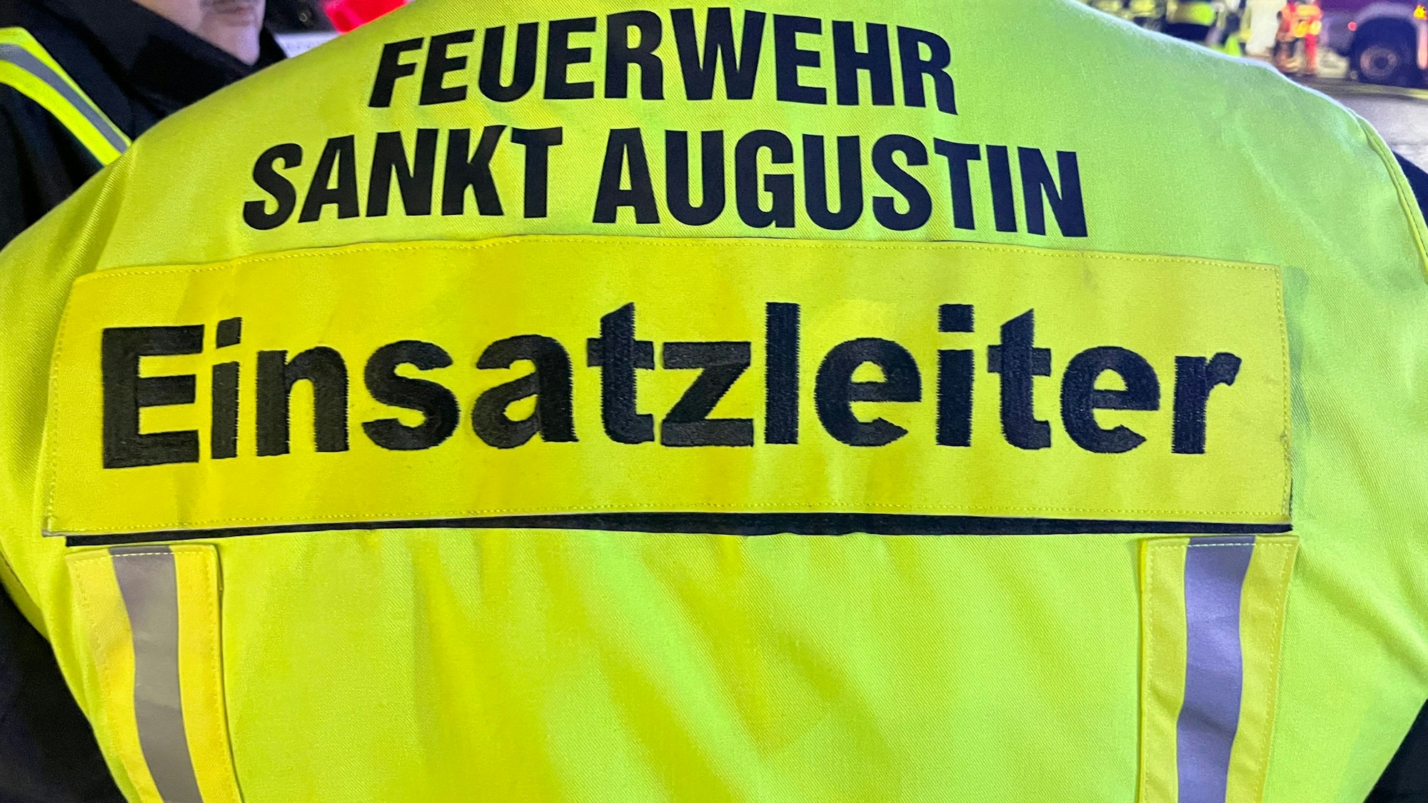Der Einsatzleiter der Feuerwehr Sankt Augustin trägt eine gelbe Weste.