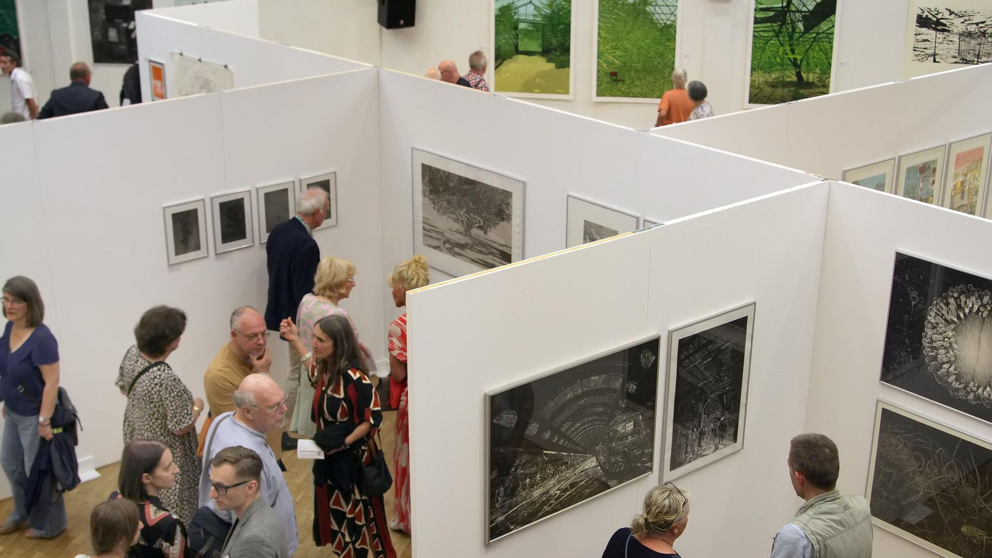 Auf dem Bild sind Ausstellungsbesucher von oben zu sehen.