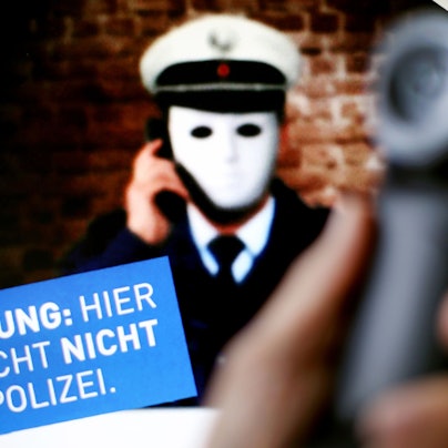 1.10.2017, Nordrhein-Westfalen, Düsseldorf: Ein Telefonhörer ist vor einem Plakat der Polizei NRW mit der Aufschrift «Achtung: Hier spricht nicht die Polizei» zu sehen.