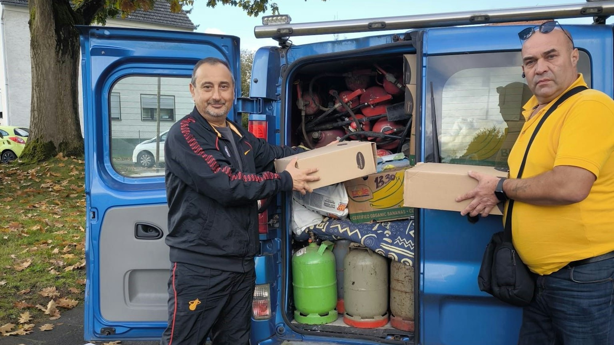 Zwei Männer bepacken einen Transporter mit Hilfsgütern für die Menschen in der Ukraine.