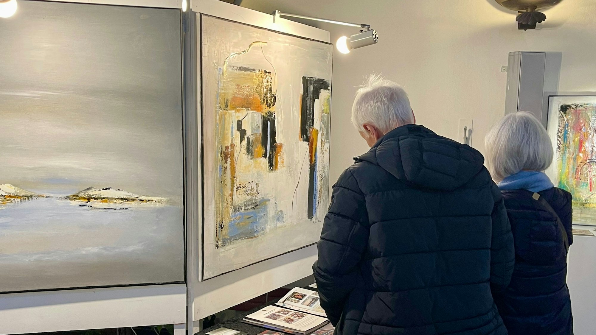 Ein Mann und eine Frau betrachten Kunstwerke.