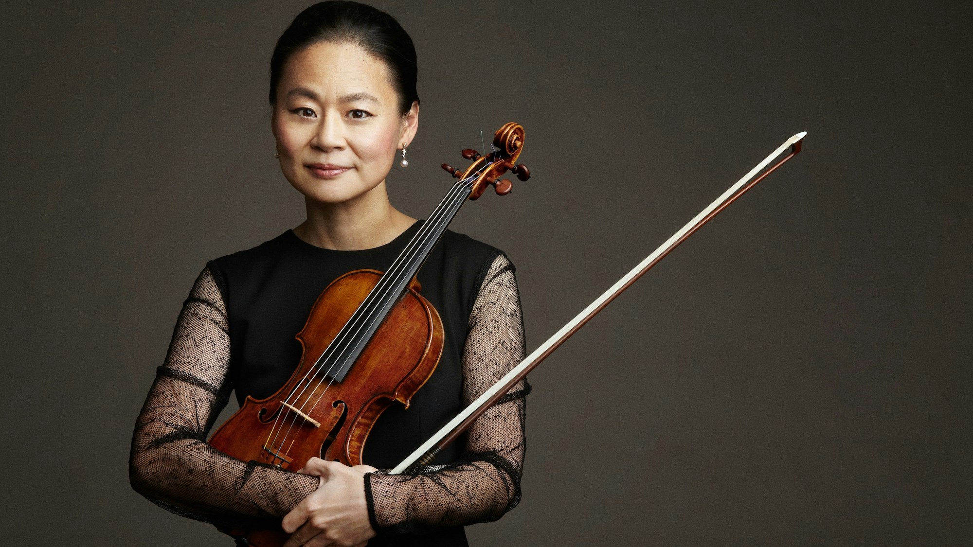 Midori hält eine Violine im Arm.