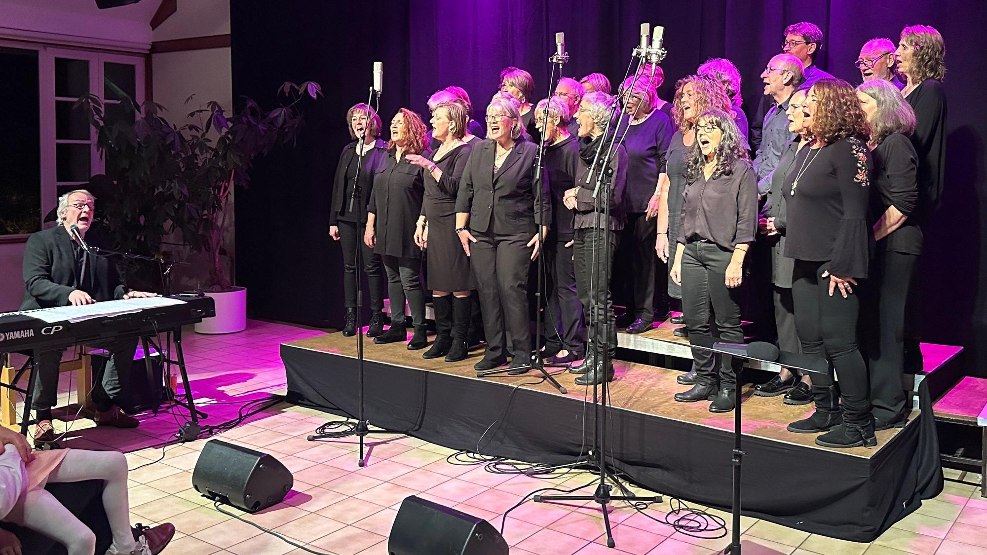 Ein Gospelchor steht auf einer Bühne.