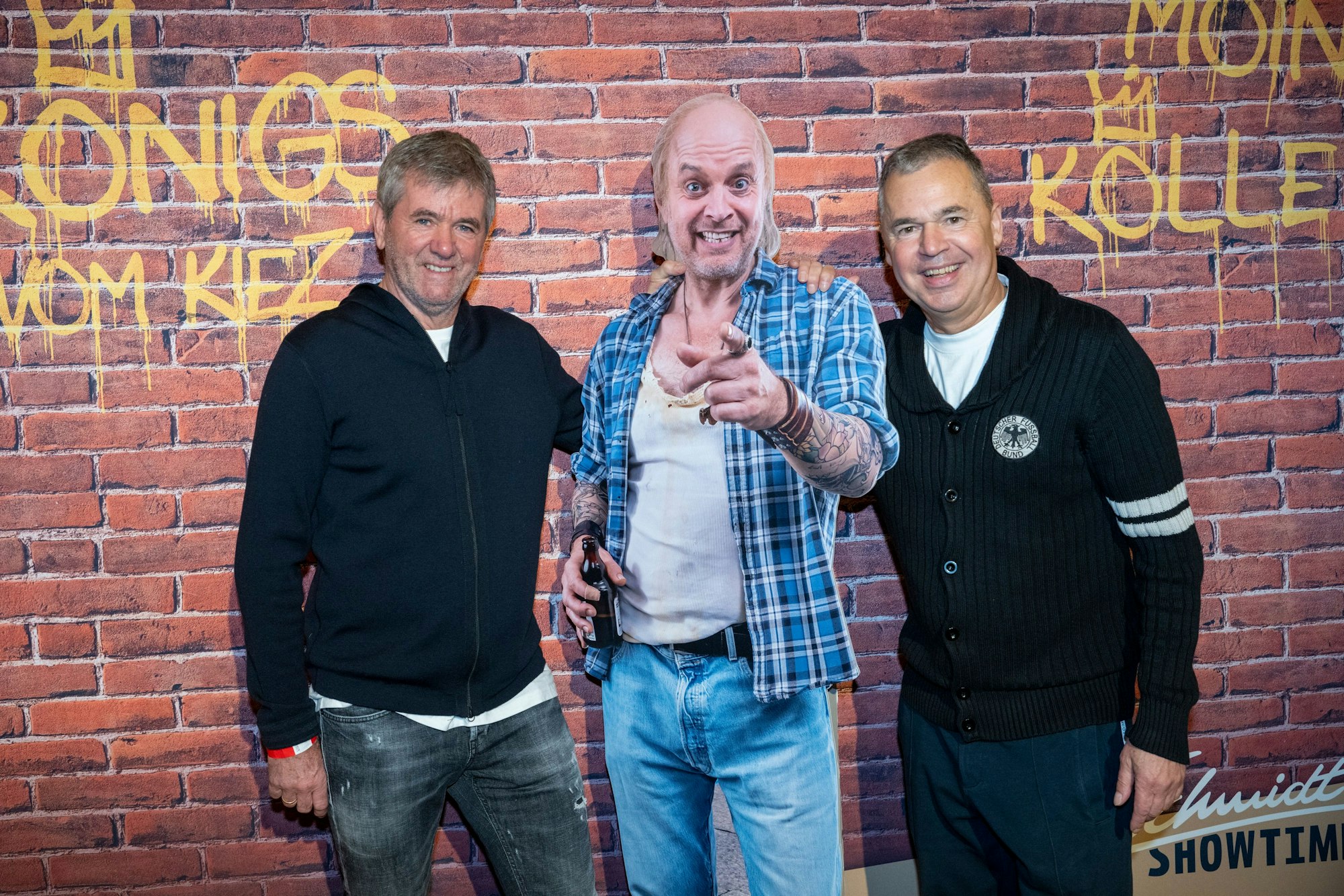 Friedhelm Funkel (l.) und Andreas Rettig posieren bei der Premiere mit dem Pappaufsteller vom Käpt'n.