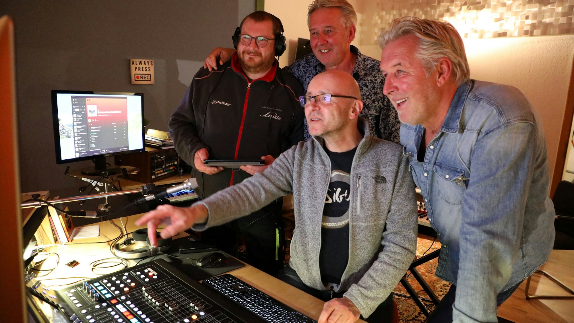 Norbert und Frank Wielpütz stehen mit Produzent und Gitarrist Ralf Hahn und Tontechniker Chris Hansen a Mischpult.