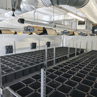 In einem Raum sind Halterungen und Geräte für den Anbau von Cannabis-Pflanzen aufgebaut.