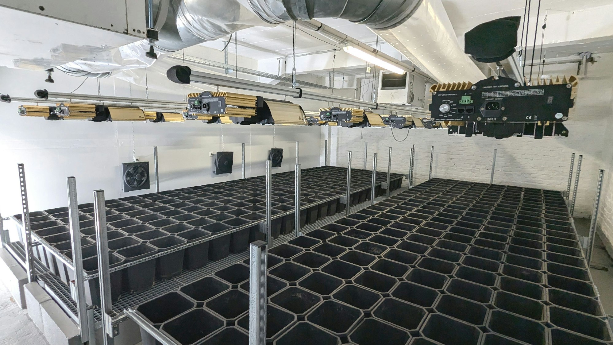 In einem Raum sind Halterungen und Geräte für den Anbau von Cannabis-Pflanzen aufgebaut.