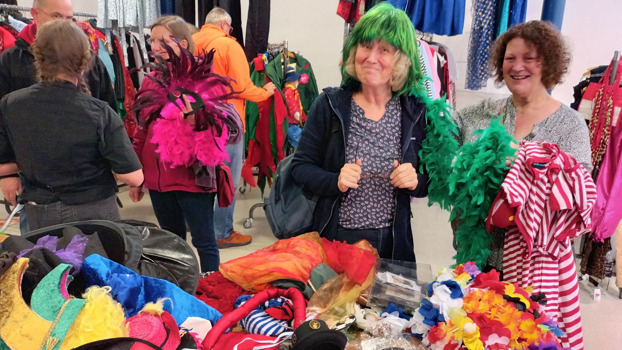Zwei Frauen vor einem Tisch mit Karnevals-Accessoires