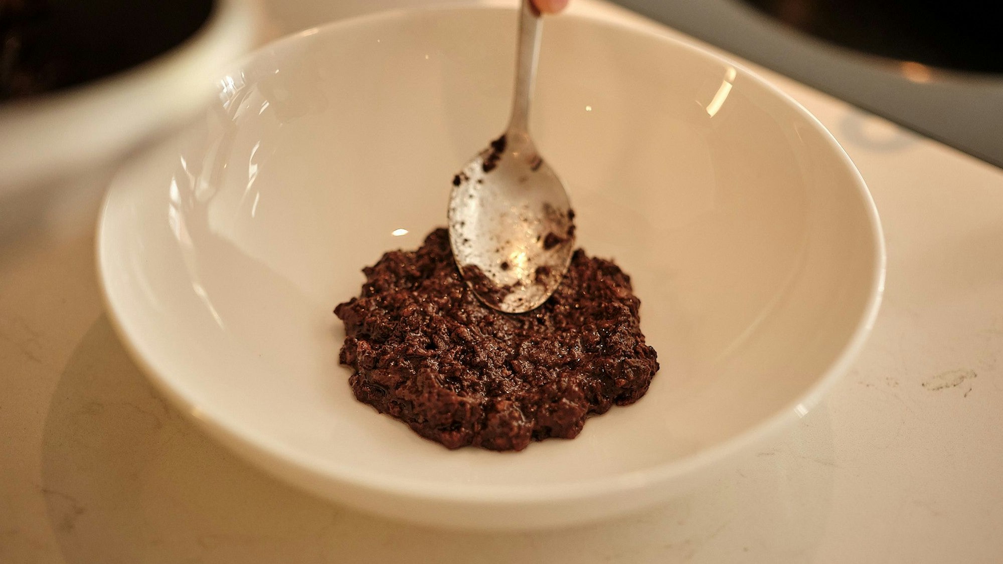 Die Blutwurst glatt rühren und mittig auf einen vorgewärmten tiefen Teller geben.