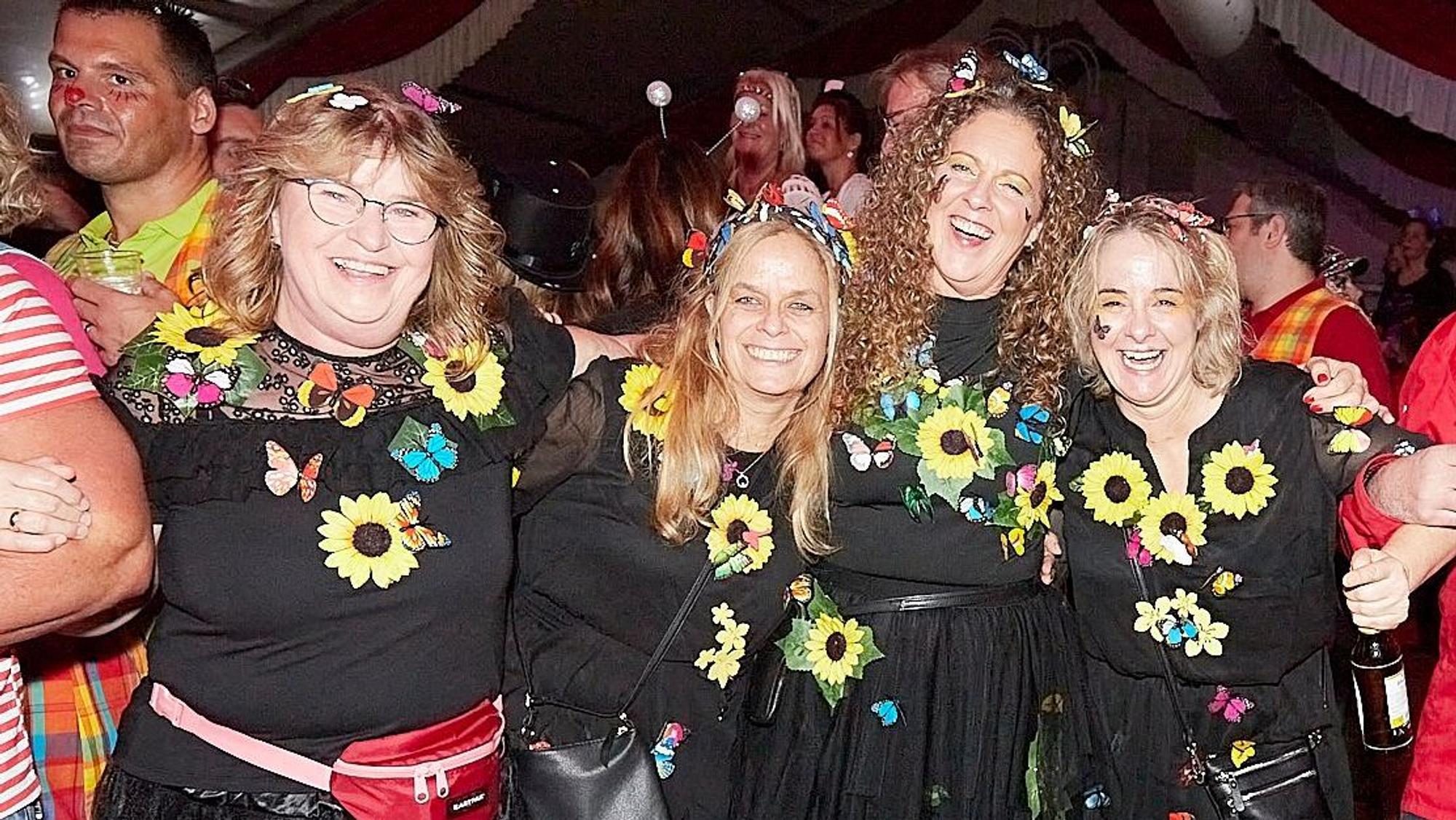 Eine Vierergruppe mit Blumenkostümen schaut fröhlich in die Kamera.