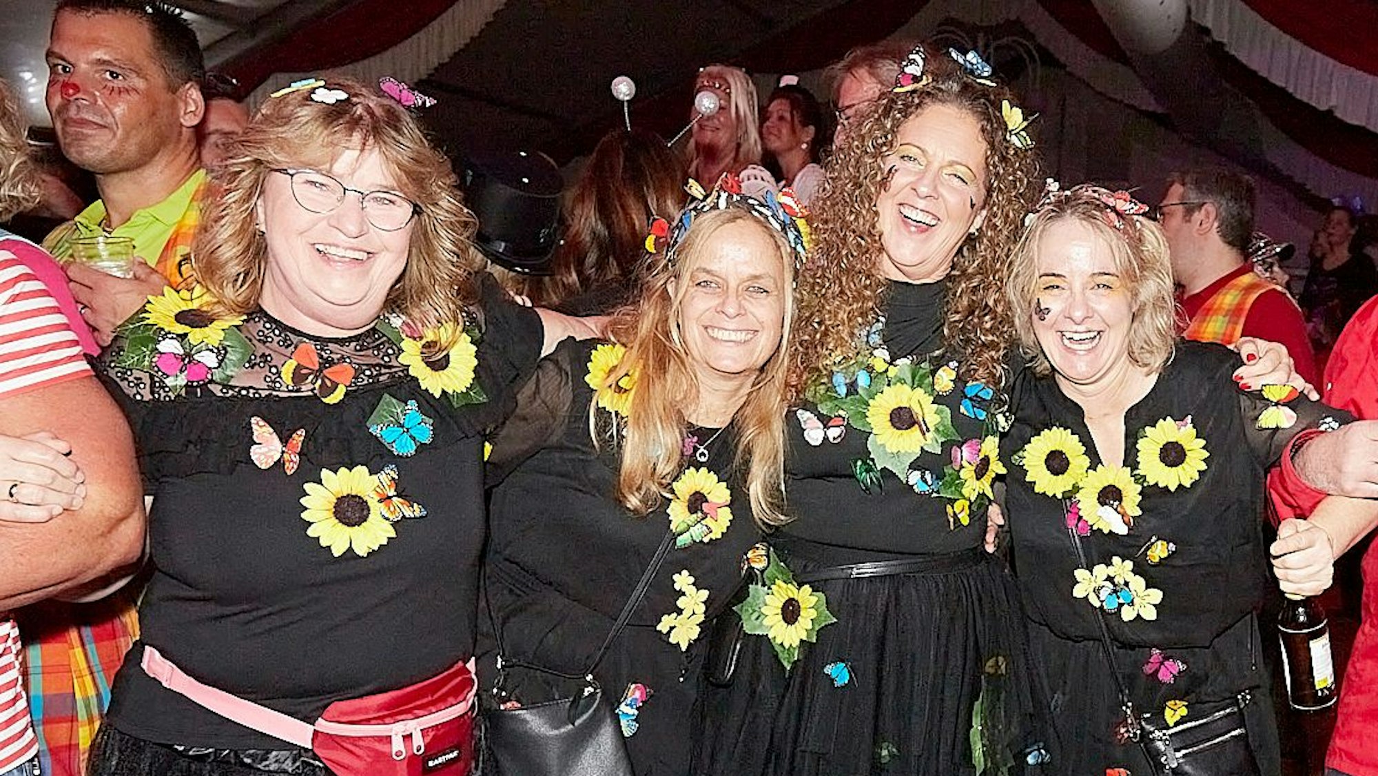 Eine Vierergruppe mit Blumenkostümen schaut fröhlich in die Kamera.
