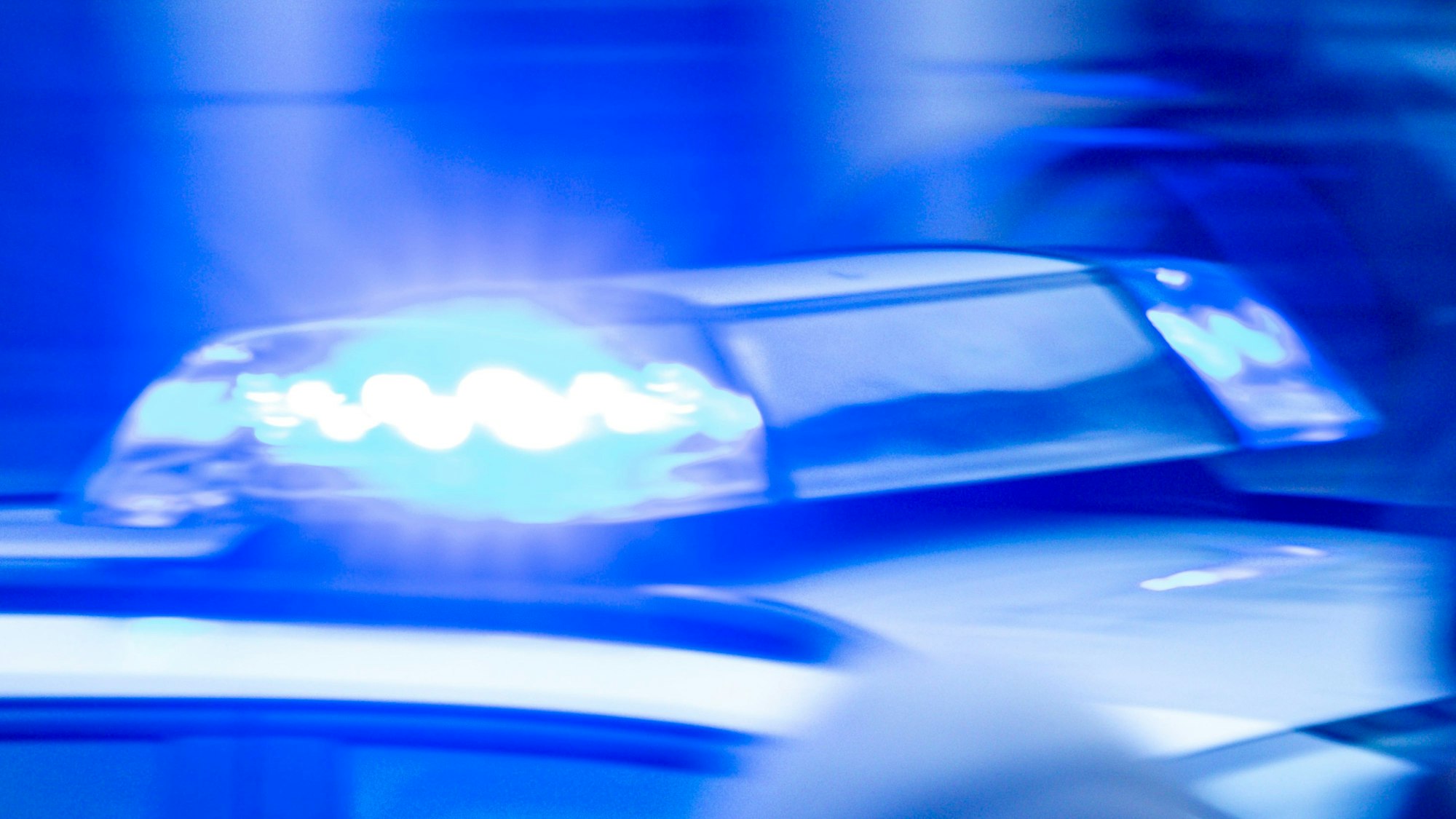 Ein Streifenwagen der Polizei ist mit Blaulicht im Einsatz.