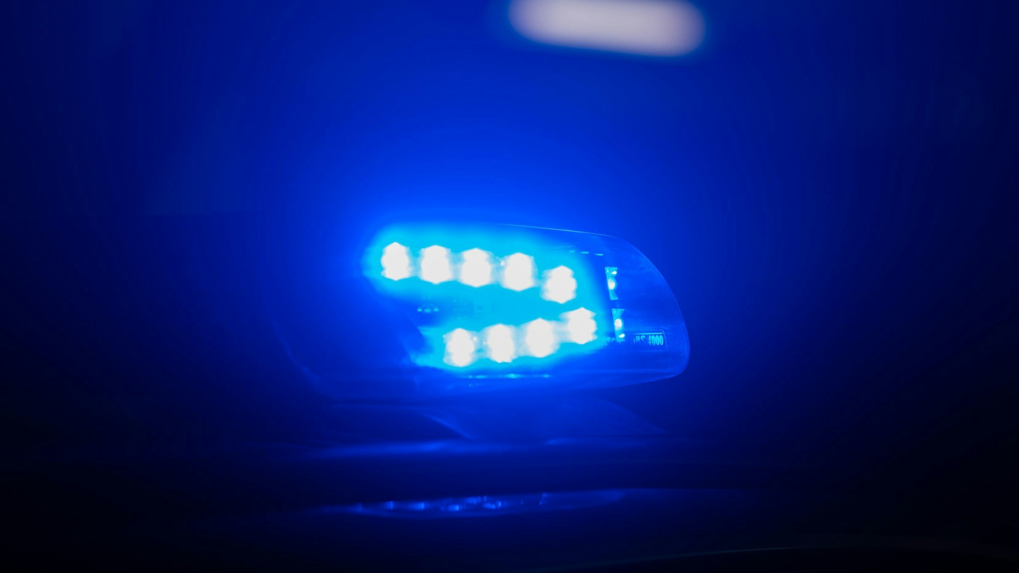 Ein Blaulicht leuchtet auf dem Dach eines Polizeiautos.