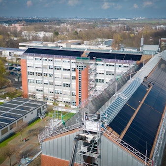 Die Luftaufnahme zeigt die Solarmodule auf den Schrägflächen des Rathausdachs.