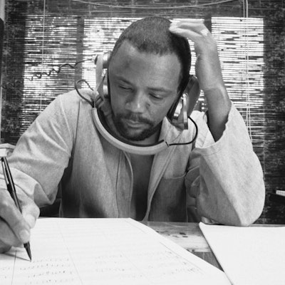 Der Komponist Quincy Jones im Oktober 1974 in seinem Heimstudio beim Schreiben von Musik, während er eine Aufnahme über seine Kopfhörer hört.
