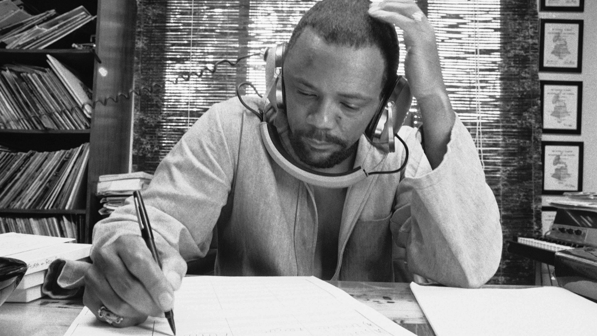 Der Komponist Quincy Jones im Oktober 1974 in seinem Heimstudio beim Schreiben von Musik, während er eine Aufnahme über seine Kopfhörer hört.