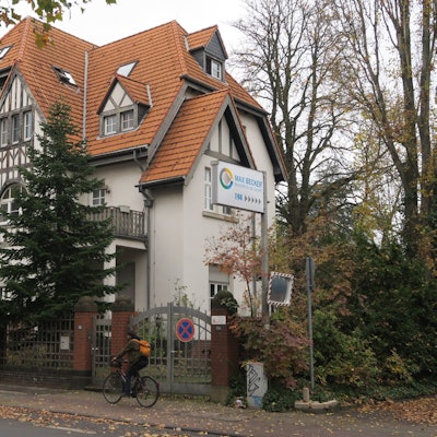 Blick auf ein Tor und ein Schild, das den Eingang zum Max-Becker-Areal markiert.