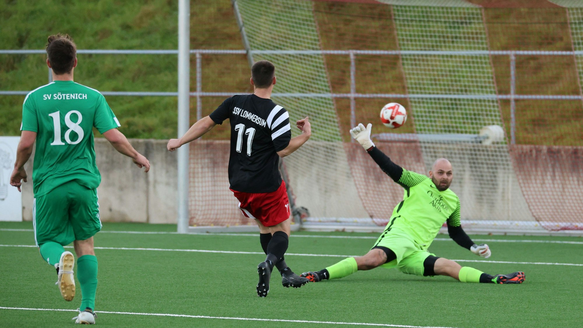 Das Bild zeigt den Lommersumer Spieler beim Torschuss. Sötenichs Torwart versucht, den Ball zu parieren. Dies misslingt aber.