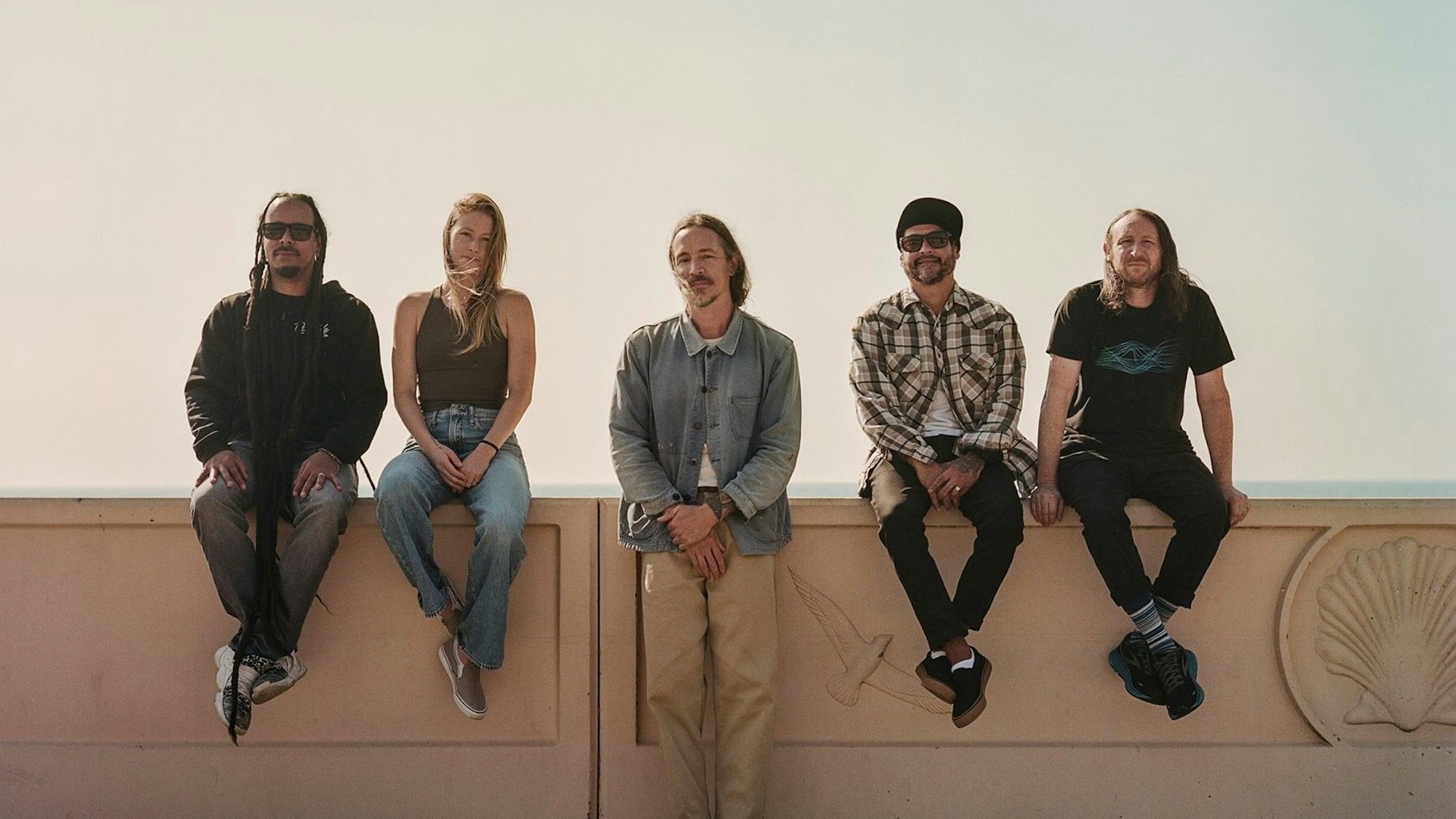 Die Band Incubus sitzt auf einer Mauer