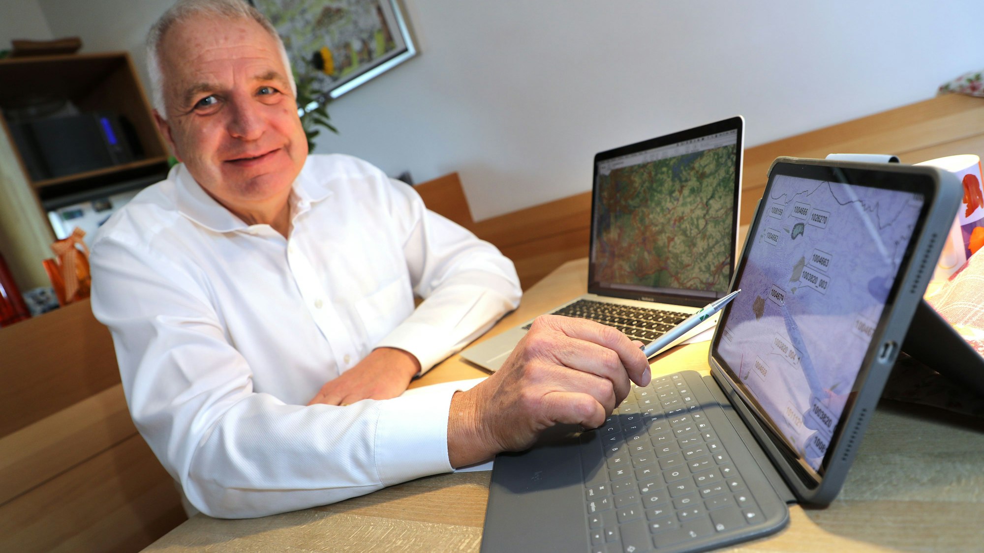 Regionalratsvorsitzender Rainer Deppe sitzt an zwei Laptops auf dem Küchentisch in seinem Haus in Overtah-Hufenstuhl.