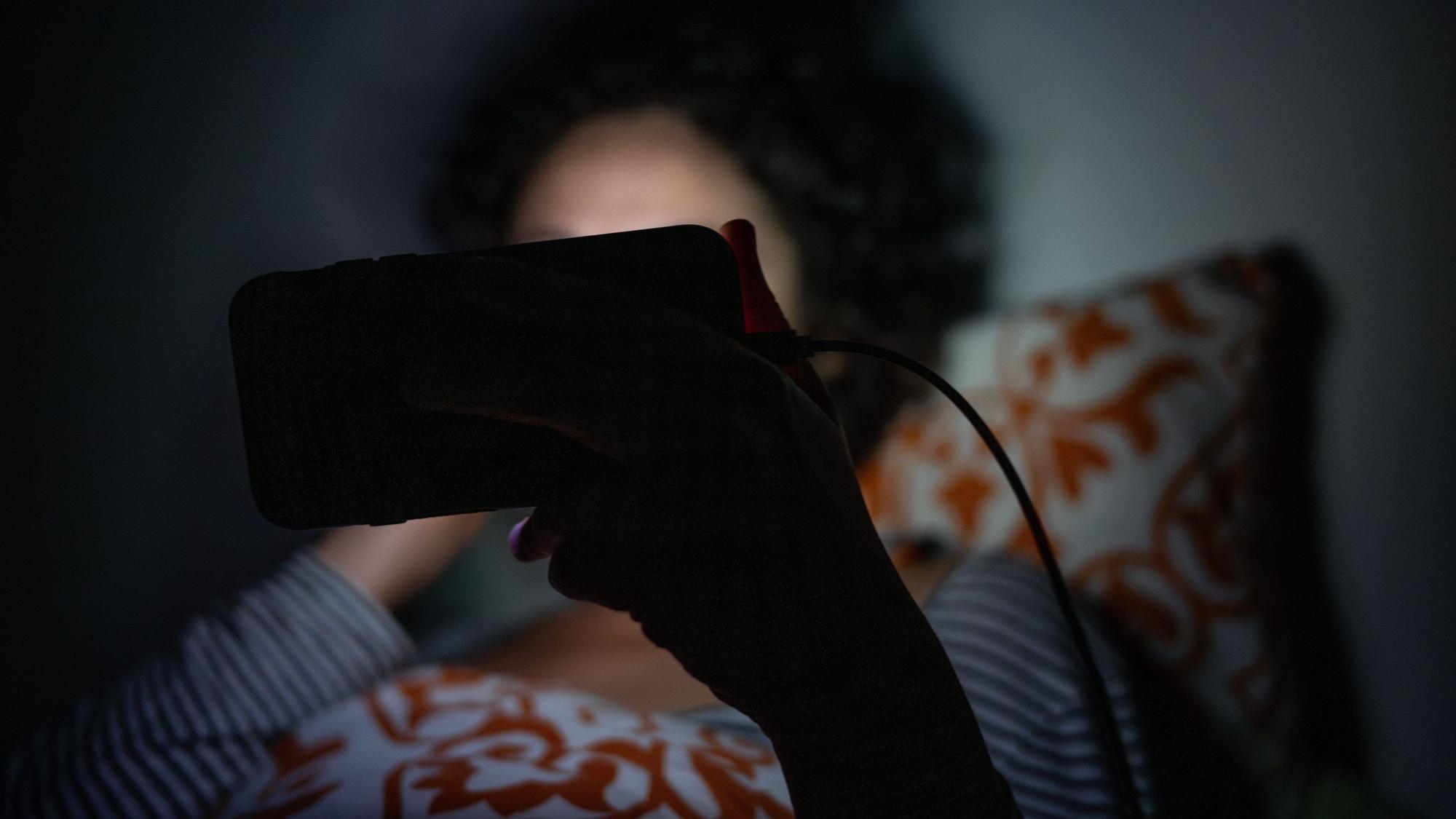 ILLUSTRATION - 01.09.2023, Berlin: Eine Frau schaut im Bett eine Sendung auf dem Smartphone. (zu dpa: «Mehr Menschen leiden unter Schlafstörungen») Foto: Sebastian Gollnow/dpa/dpa-tmn +++ dpa-Bildfunk +++