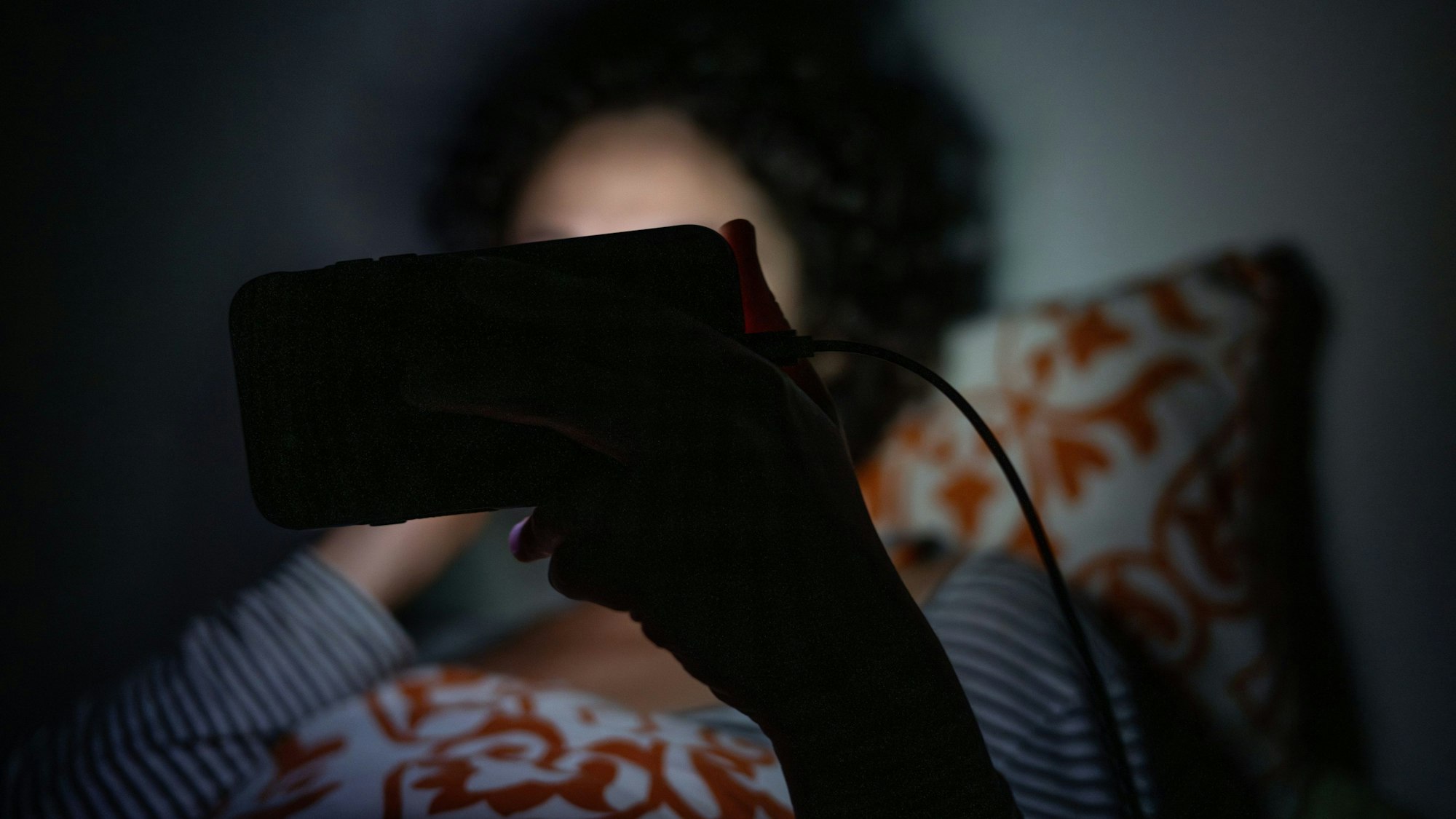 ILLUSTRATION - 01.09.2023, Berlin: Eine Frau schaut im Bett eine Sendung auf dem Smartphone. (zu dpa: «Mehr Menschen leiden unter Schlafstörungen») Foto: Sebastian Gollnow/dpa/dpa-tmn +++ dpa-Bildfunk +++