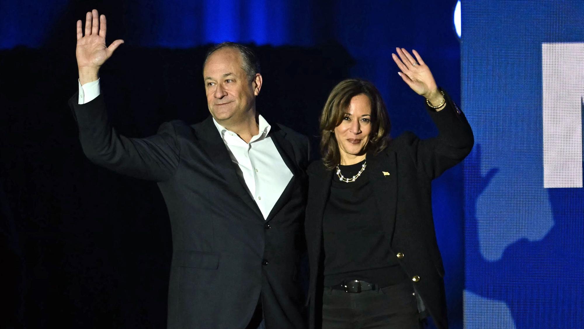 Die demokratische Kandidatin Kamala Harris und ihr Ehemann Doug Emhoff winken auf einer Veranstaltung ihren Unterstützern zu.
