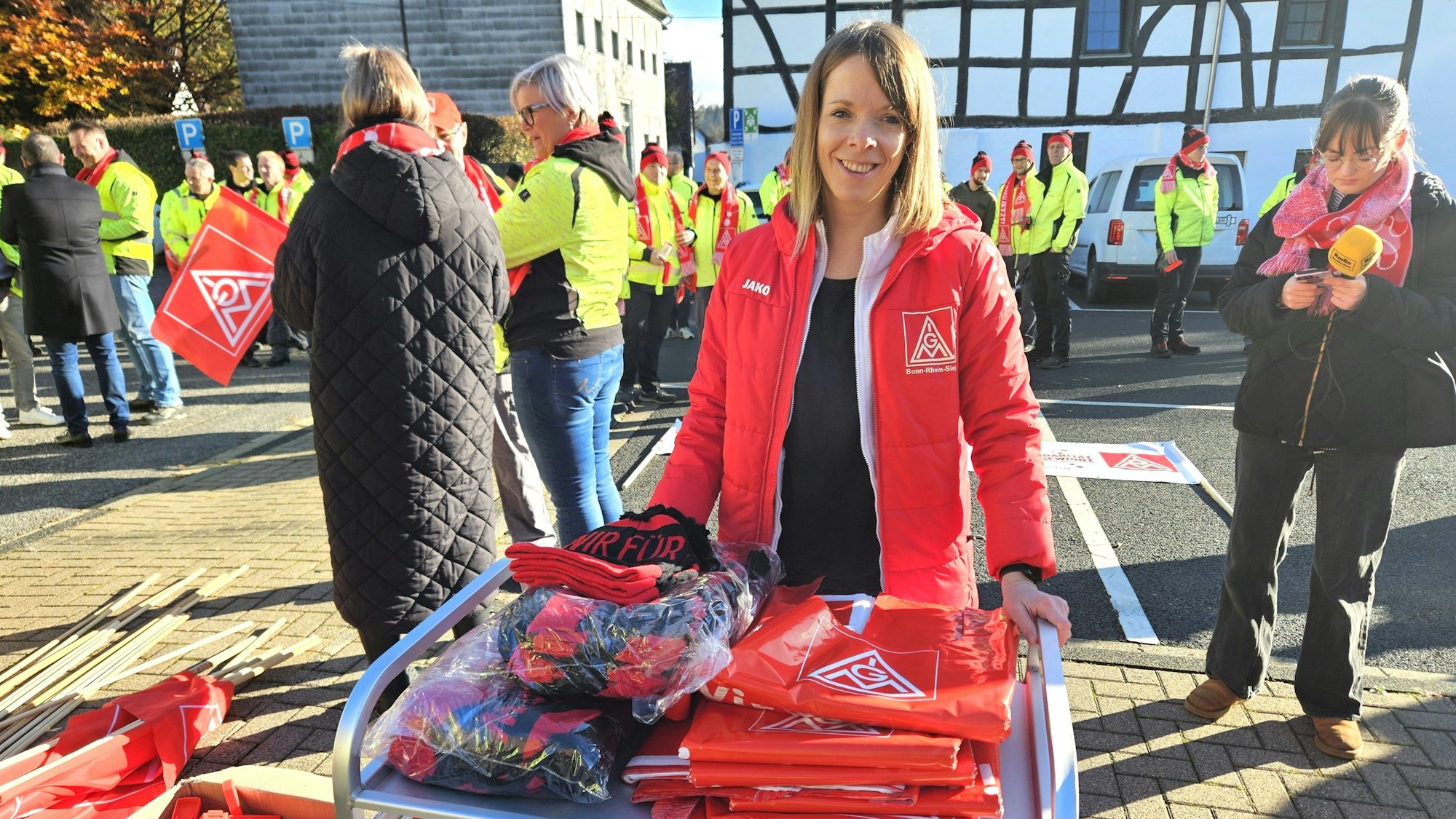 Melanie Bensberg steht vor einen Tisch mit Fahnen und Mützen..