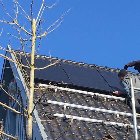 Die Männer befestigen ein Photovoltaik-Modul auf der Unterkonstruktion.