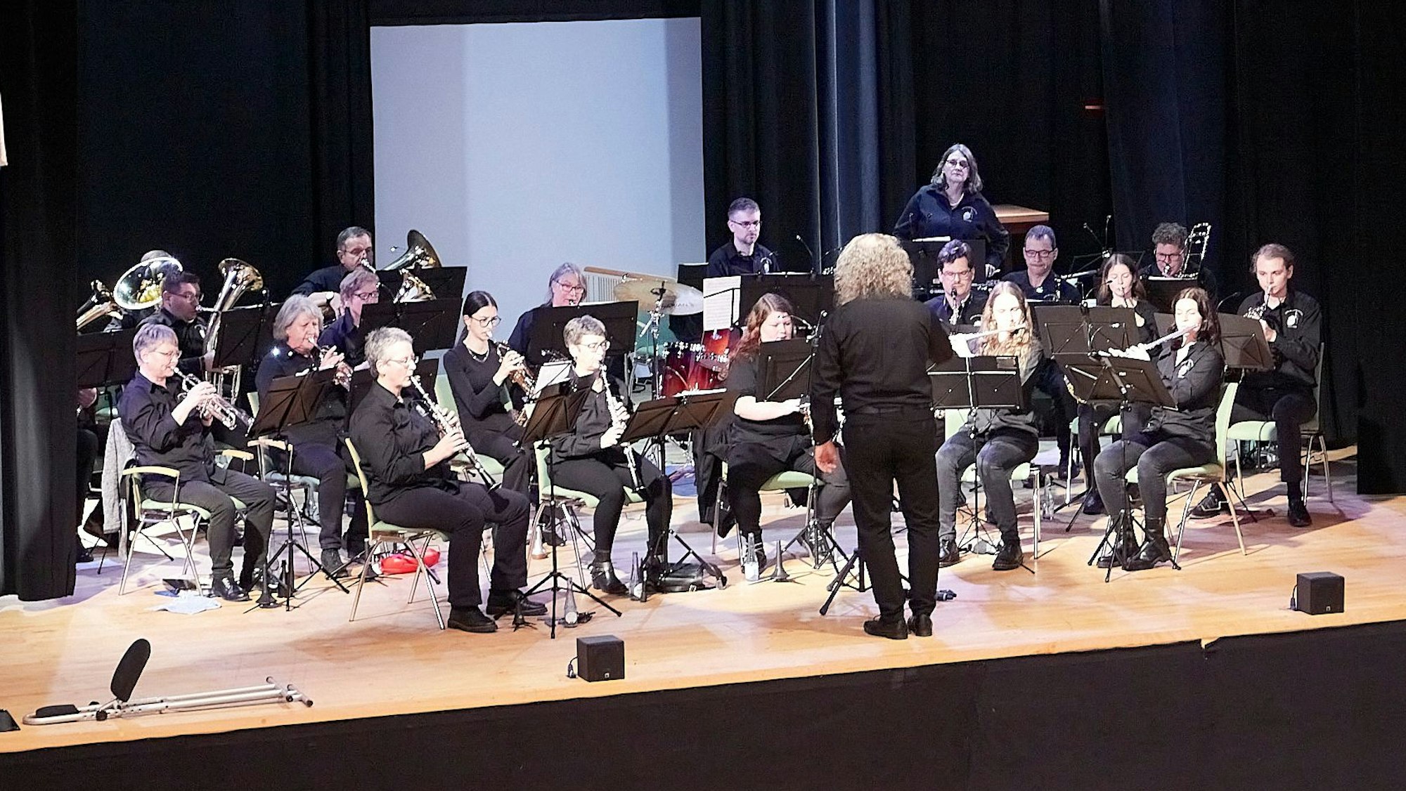 Ein Blasorchester spielt auf einer Bühne.