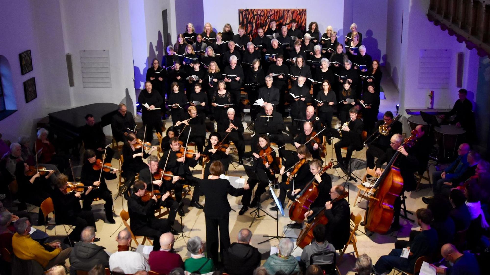 Ein Chor und ein Orchester bei einem Konzert in einer Kirche.