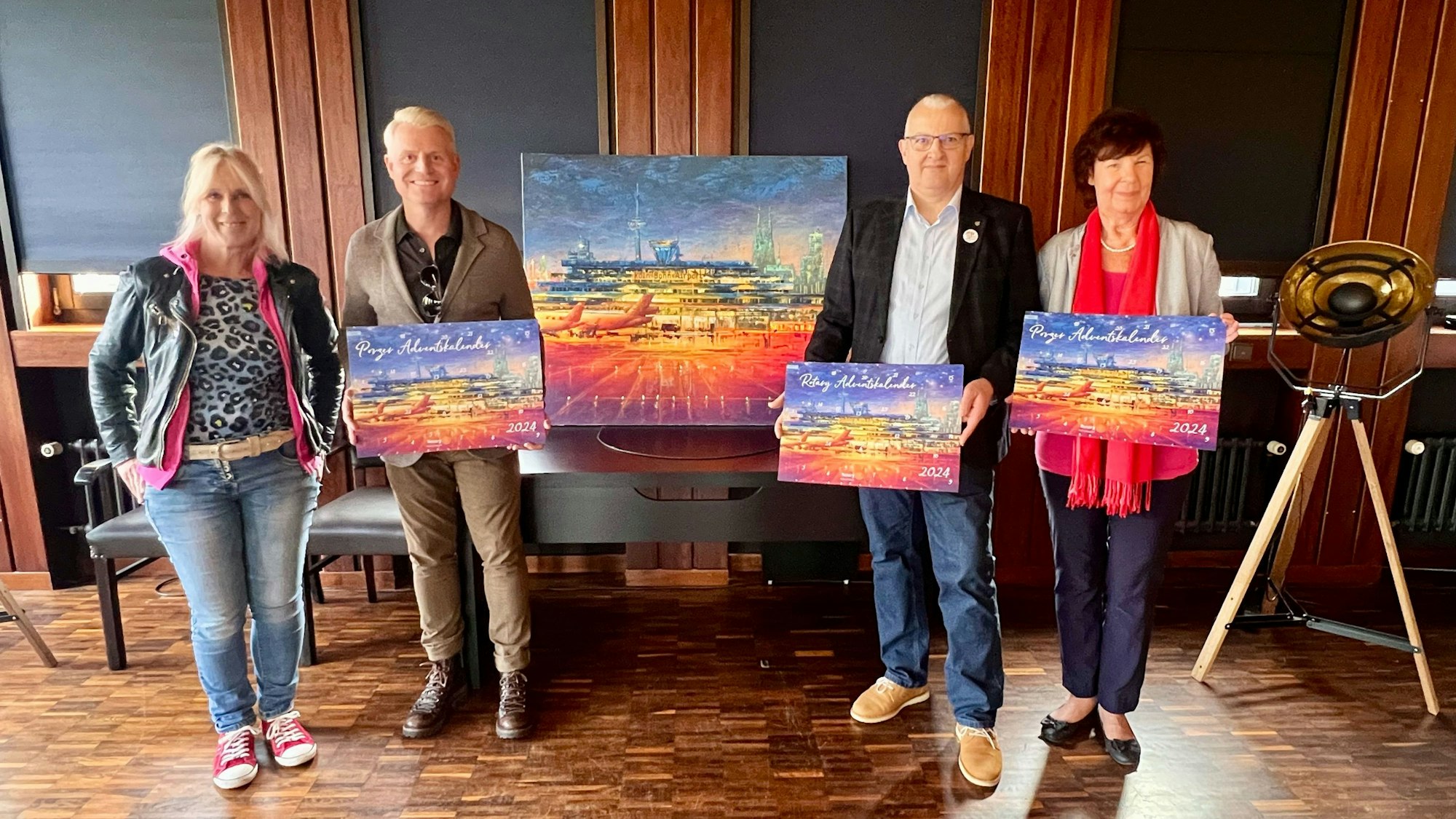 Zwei Männer und zwei Frauen halten Exemplare des Porzer Adventskalenders.