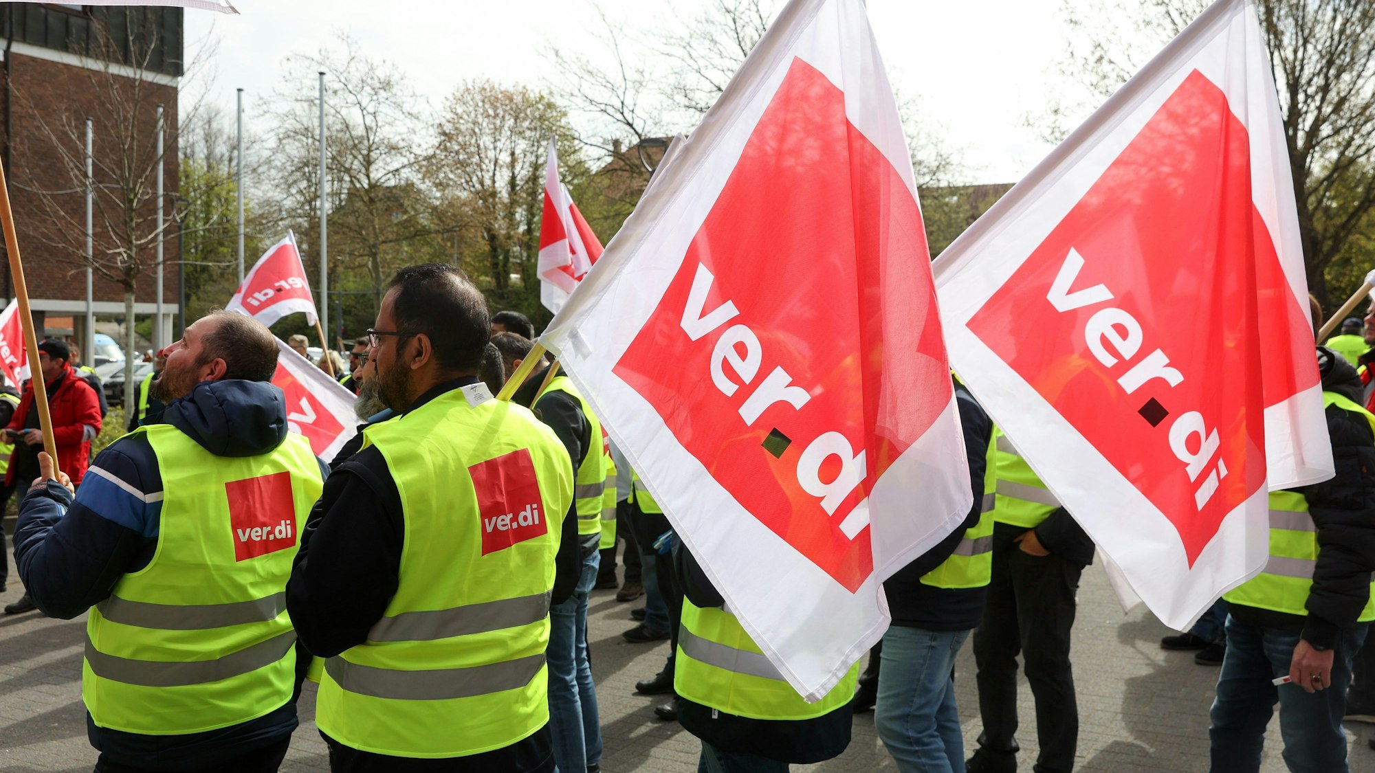 Mitarbeiter der Verkehrsbetriebe stehen während eines Warnstreiks auf einer Kundgebung zusammen.